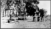 In the 1931 photo, A.L. Lugn (from left), Harry Burleigh and a man known only as Miller are using a retractor to retrieve a section of 3-inch pipe stuck in some gravel when the hole caved in. This shows a rear view of the new Dempster rotary-hydraulic rig. The rig had a wooden mast mounted on a trailer assembly. The Dempster cost $3,600 and was used for nine seasons.