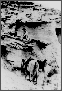 Messrs. Wortman and Gidley working on "Metamynodon" beds, probably in northwestern Nebraska, 1894. The face of the man on the left is partially obscured by a bandana, no doubt for protection from the dust. This photo was taken during the early days of the Nebraska Geological Survey, under the direction of E.H. Barbour, when the duties of the geological survey, the state museum and the geology department were combined in one organization.