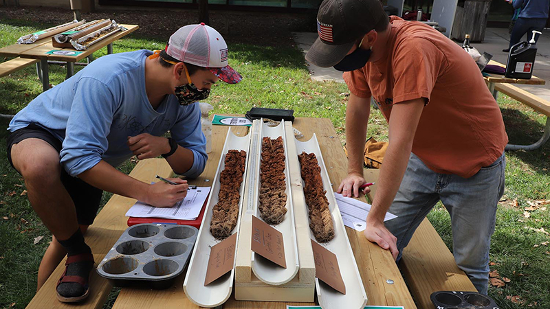 Students look a features and horizon in soil core