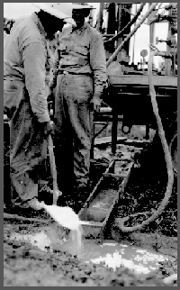 Ellis Gordon with shovel, adding lime to drilling "mud". In certain situations the lime causes the drilling mud to thicken which helps to move the cuttings to the surface.