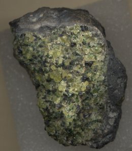 Volcanic bomb with numerous peridot crystals, New Mexico. these bombs are broken apart and crystals are size-sorted with sieves.