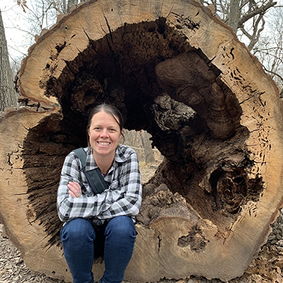 Ann Powers finds a resting spot in the hollowed-out remains of what appeared to be a bur oak on the Arbor Day Farm in Nebraska City. The tree lay in a play area for kids but has since been removed. She said trees can live for a long time with columns of decay and decay can result from something as simple as squirrels chewing on the branches. 
