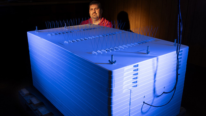 Trenton Franz, professor of hydrogeophysics at Nebraska, stands beside the newly installed neutron monitor, one of only three in the United States.