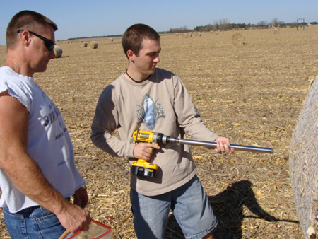 Greg Teichmeier and Dan Hatch prepare to draw a bale sample for analysis of moisture and carbon content in a biomass removal study at the Carbon Sequestration field sites.