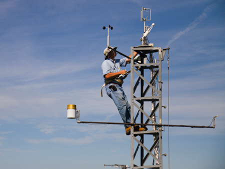 Tom Lowman performs maintenance on the tower eddy covariance sensors at one of the Carbon Sequestration field sites.